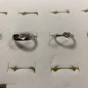 925 Silverpläterade Love Par ringar - Säljer två stilrena ringar i 925 Silverpläterade Ena ringen har en söt knutdetalj framtill, medan den andra har en enkel, slät design. Perfekta att bära tillsammans eller var för sig för en clean look. Stämplat, 155kr/ par , helt ny 