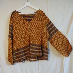 Blus från Indiska  - Blus från Indiska i gult med ett mörkt rött mönster. Luftig och sval, strlk XL.