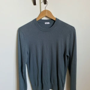 Mörkgrå stickad tröja från Filippa K - Snygg grön stickad tröja från Filippa K med rund halsringning och långa ärmar. Tröjan har en klassisk och stilren design som passar perfekt till jeans eller kostymbyxor. Mjuk och skön kvalitet som känns lyxig mot huden. Skriv för mer frågor//elvin