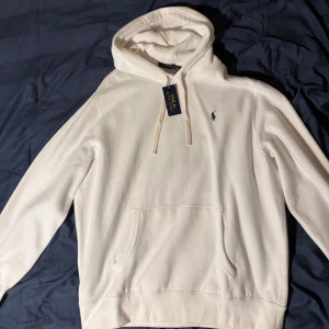 Vit Polo Ralph Lauren Hoodie - Polo Ralph Lauren Hoodie Säljer en helt oanvänd hoodie från Polo Ralph Lauren i storlek XL. Den är bekväm, passar till det mesta och har bra kvalitet.  • Färg: vit • Storlek: XL • Skick: aldrig använd   💸 Nypris: 1695 kr 💰 Säljes för: 800 kr  Kan hämtas eller skickas om köparen betalar frakten.