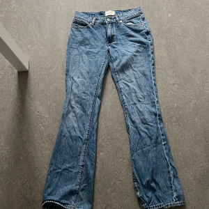 Blå bootcut jeans från Abrand Jeans - Snygga blå lågmidjade bootcut jeans från Abrand Jeans i ekologisk bomull. Klassisk femficksmodell med ljus tvätt och bruna sömmar. Bakfickan har en liten brun läderpatch med logga. Perfekta för dig som gillar en retroinspirerad look.