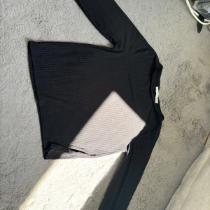 Svart ribbad långärmad tröja 157 - Svart långärmad tröja från 157 i storlek S. Tröjan är ribbad och har en klassisk, enkel design med rund halsringning. 