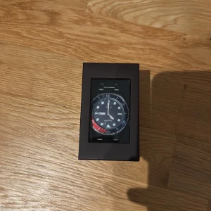 Sekonda herrklocka med stållänk - Snygg herrklocka från Sekonda med blå urtavla, datumvisning och tydliga indexmarkeringar. Klockan har en robust silverfärgad länk i metall och vridbar ring i blått och rött. Perfekt accessoar för dig som gillar stilren och sportig design. Om du har några funderingar är det bara att höra av sig:)