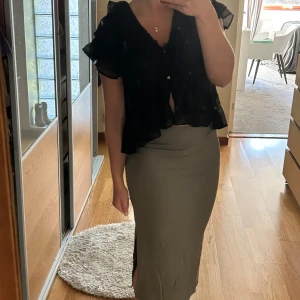 Ribbad långkjol med slits - Säljer en långkjol i ribbat material med tight passform. Kjolen har en snygg slits på sidan som ger extra edge. Perfekt för dig som gillar stilrena och enkla plagg med en twist. Superenkel att matcha med både klackar och ballerinas.