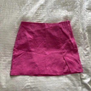 Rosa kortkjol från H&M med slits - Snygg rosa kortkjol från H&M i storlek 34. Kjolen har en fin passform och en liten slits framtill som ger en cool touch. 