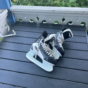 Hockey skor/ skridskor- St 40 - Snygga skridskor från Power i svart och vitt med klassisk snörning och robust design. Yttermaterialet är i syntet och skinn, med vit sula och svart tåparti. Perfekta för dig som gillar att åka skridskor på vintern. Storlek 40