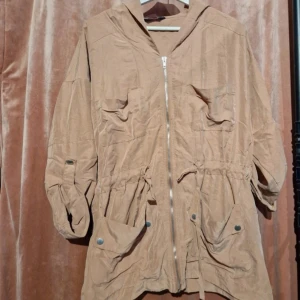 Beige parkajacka från Miss Selfridge - Snygg tunn parkajacka från Miss Selfridge med huva, dragkedja och stora fickor framtill. Jackan har snörning i midjan för en schysst passform och är tillverkad i bomull. Perfekt för lager-på-lager och chill vår- eller höstdagar.