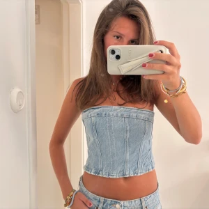 Ljusblå jeans tubtopp från Zara - Säljer en snygg ljusblå tubtopp i jeanstyg från Zara. Toppen är croppad och har markerade sömmar 