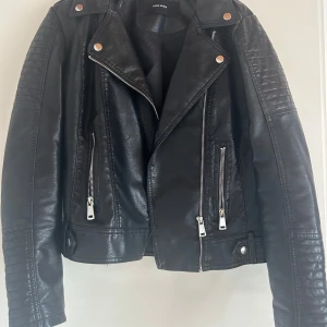 Svart skinnjacka från Vero Moda - Snygg svart skinnjacka från vero Moda i bra skick. Ena lappen är borta med storlek men passar M/L..