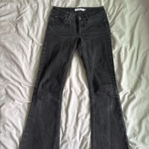 Svarta bootcut jeans från Wrangler - Snygga svarta bootcut jeans från Wrangler med klassisk femficksdesign och subtila slitningar❤️Jeansen har normal passform och är tillverkade i mjukt denimtyg med stretch för extra komfort. 