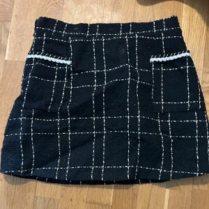 Vitrutig svart kjol med gulddetaljer - Jag säljer en matchande kofta 