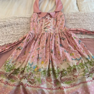 Söt rosa lolitaklänning från Bodyline - Supergullig rosa lolitaklänning med Peter Pan-krage, snörning fram och bak, långa ärmar och ett magiskt sagomotiv med ballonger, fåglar och söta figurer. Klänningen har vita prickar och volangkant nertill. Perfekt för dig som älskar kawaii och unika prints! Den är i storlek S!!<3