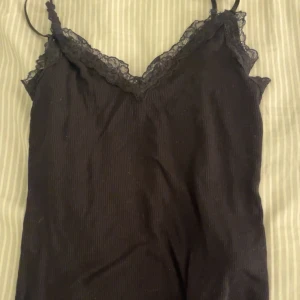 Svart ribbad linnetopp med spets - Snyggt spetslinne som är oanvänt!