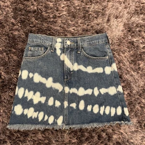 Blåvit jeanskjol från &Denim - Cool kort jeanskjol från &Denim med blå och vita batikmönster. Kjolen har klassiska fem fickor, rå fransig kant nertill och bälteshällor. Använd 1 gång. Alla priser kan diskuteras 🤍