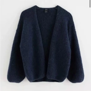 Mörkblå kofta från Lindex  - Säljer en mysig mörkblå kofta från Lindex . Den är perfekt för kyliga dagar med sin fluffiga textur och öppna design. Koftan har långa ärmar och en avslappnad passform. Perfekt att slänga på sig för en stilren look. Original pris 400kr