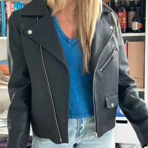 Svart skinnjacka med dragkedjor - Snygg svart skinnjacka från & Other Stories. Jackan har en asymmetrisk dragkedja framtill och två snedställda fickor med dragkedjor. Köpt för 5000kr säljer nu billigare pga för liten.. 