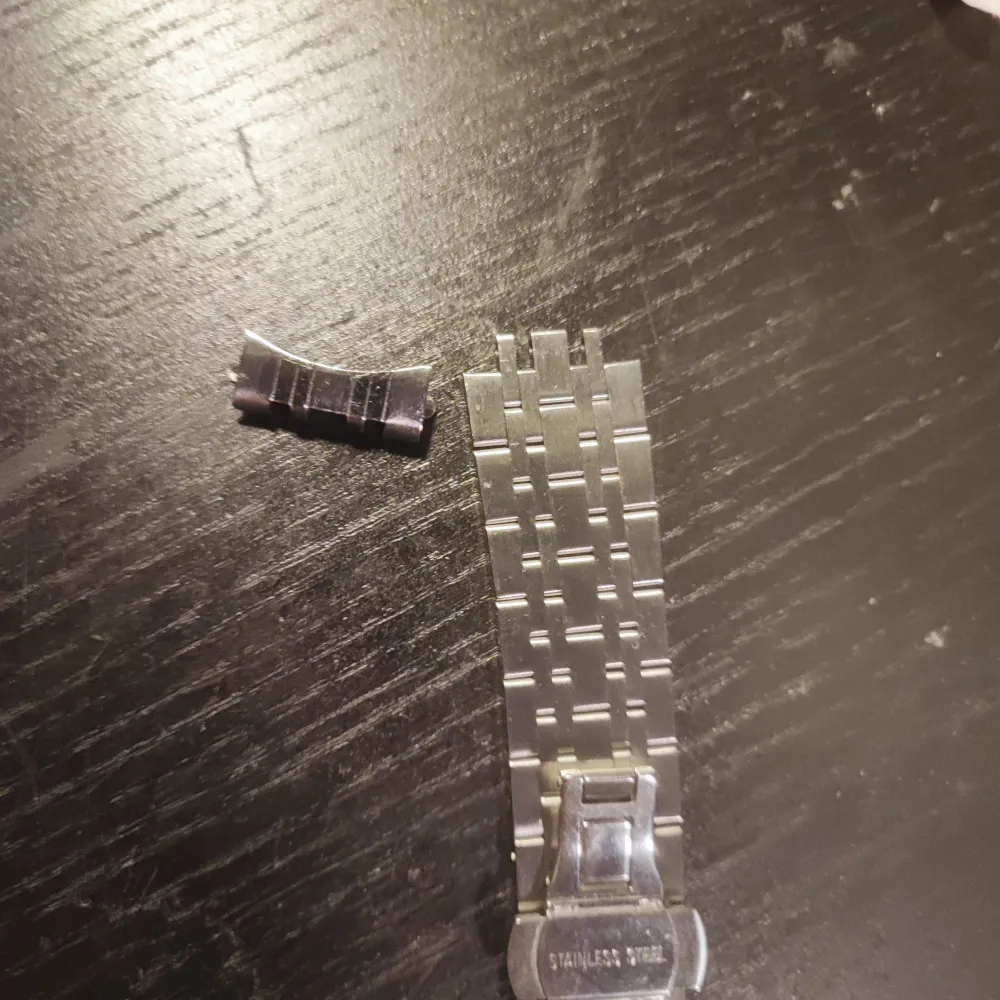 Elegant silverfärgad klocka från Citizen med en stilren urtavla och länkarmband i rostfritt stål. Klockan har en klassisk design med en rund boett och tydliga markeringar. Perfekt för den som söker en tidlös accessoar. Armbandet är av på ena sidan men inget som inte en 50 lapp kan fixa . Asusteet.