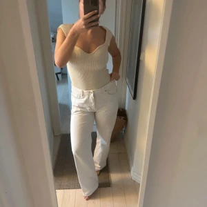 Vita jeans - Snygga vita jeans med hög midja och rak passform. Perfekta för en stilren look. De har klassiska femficksdetaljer och en knappgylf.