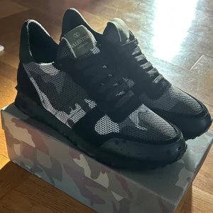 Valentino rockrunners - Snygga Valentino skor  med ett kamouflagemönster i svart och grått. Använd 1 gång skick 10/10 hör av er vid intresse strl 45