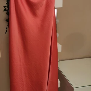 Korallfärgad långkjol från Y.A.S - Elegant korallfärgad långkjol från Y.A.S. Perfekt för speciella tillfällen med sin stilrena design och vackra fall. Kjolen har en enkel och sofistikerad look som gör den lätt att matcha med olika toppar och accessoarer. Ej använd men utan prislapp. Ordpris: 398:-