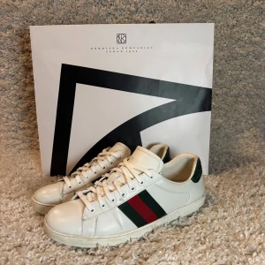 Gucci ace skor - Tja säljer nu ett par Gucci ace skor i storlek 43 med krokodil skin vid hälen, skicket är väldigt bra på dom. Dock lite små defekter som man ser på bild 1 och 2 och lite målade vid små defekter på båda insidorna av skona, men annars 10/10. Ny pris 9000, Inget OG följer med!! Skriv om du har några frågor och va inte rädd att lägg bud!!!