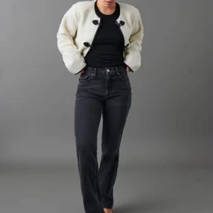 Svarta jeansbyxor - Snygga svarta jeans med mellanhög midja och klassisk femficksdesign. Byxorna har en straight passform som ger en tidlös look. Perfekta för en stilren vardagsoutfit.