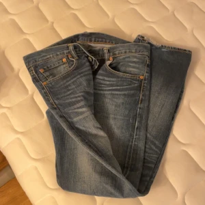 Blå jeans från Levi's - Säljer ett par klassiska blå Levi's jeans i modell 501. De har en straight passform och är tillverkade i slitstarkt denim. Perfekta för en avslappnad stil med fem fickor och knappgylf.