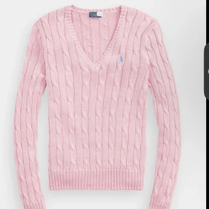 Rosa stickad tröja från Ralph Lauren - Säljer en söt rosa stickad tröja från Ralph Lauren. Tröjan har en rund halsringning och knappar vid axeln för en extra touch. Perfekt för en mysig dag ute eller hemma. 💖 ( det var den närmaste likadana modellen jag hitta på nätet) nypris 3000 passar strl XS