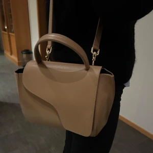 Beige handväska från ATP Atelier - Snygg beige handväska från ATP Atelier i skinn. Väskan har en stilren design med ett lock och en axelrem. Väldigt fint skick och bara använd några få gånger av min mamma! Dustbag finns men tyvärr inte kvitto, men väskan köptes på NK gbg för 3 år. Hör av er för fler bilder och lämna gärna prisförslag. 