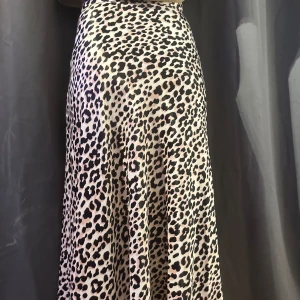 Leopardmönstrad långkjol - Snygg leopardmönstrad långkjol i ett mjukt och följsamt material. Perfekt för att ge en trendig touch till din outfit. Kjolen har en smickrande passform och är lätt att matcha med olika toppar.