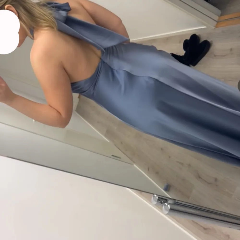 Elegant ljusblå långklänning med halterneck och öppen rygg. Klänningen har en slits framtill som ger en stilfull touch. Perfekt för speciella tillfällen. Priset kan diskuteras. Mekot.