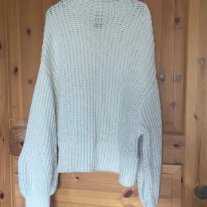 Vit stickad tröja - Mysig vit stickad tröja med långärmad design. Perfekt för kyligare dagar med sin ribbade struktur och bekväma passform.