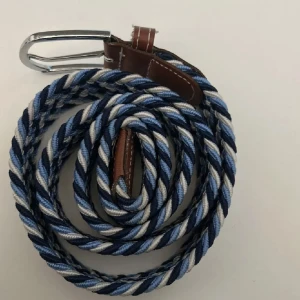 2 st flätade bälten  - 2 Snygga flätade bälte med randigt mönster i blått, vitt och svart. Röd vit svart. Perfekt för att ge en färgklick till din outfit! 