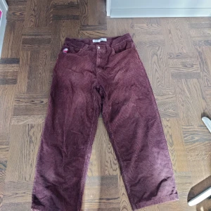 Vinröda big boy manchesterbyxor - Snygga vinröda big boy manchesterbyxor med en baggy passform. Byxorna har en klassisk design med knappar och fickor både fram och bak. 