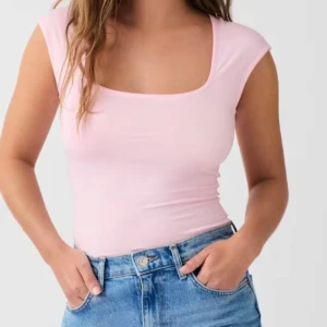 Rosa tight topp - Säljer en söt rosa tight topp med korta ärmar och rundad fyrkantig halsringning. Skriv för fler bilder eller frågor🥰