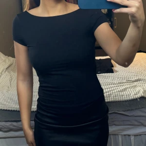 Svart topp med öppen rygg - Snygg svart topp med öppen rygg från Gina. Har lappen kvar, säljes pga att den aldrig kommit till användning! Strl S