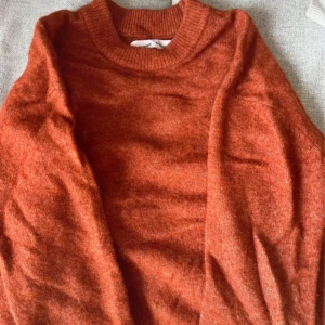 Orange stickad tröja - Säljer en mysig orange stickad tröja med rund hals och långa ärmar. Perfekt för kyliga dagar och ger en härlig färgklick till garderoben. Passar bra till både jeans och kjol. Pris kan diskuteras!!!! Är villig till att sänka priset!!!