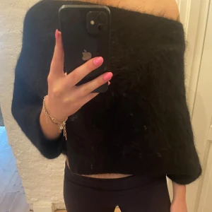 Svart offshoulder tröja från Zara mohair - Snygg svart offshoulder tröja från Zara i mohair material. Perfekt för en stilren look med en twist. Tröjan har en lös passform och trekvartsärmar som ger en avslappnad känsla.