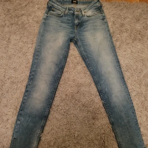 Blå jeans från Lee - Snygga blå jeans från Lee med en klassisk femficksdesign och dragkedja. De har en lätt tvättad look som ger en avslappnad stil. Perfekta för en casual outfit. Kan fraktas inom 48 Timmar. Helt ny skick.