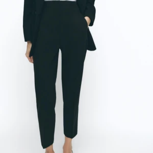 Svarta kostymbyxor - Snygga svarta kostymbyxor med hög midja och en elegant, smal passform. Perfekta för en stilren look. Byxorna har diskreta fickor och en klassisk design. Helt nya från Zara.