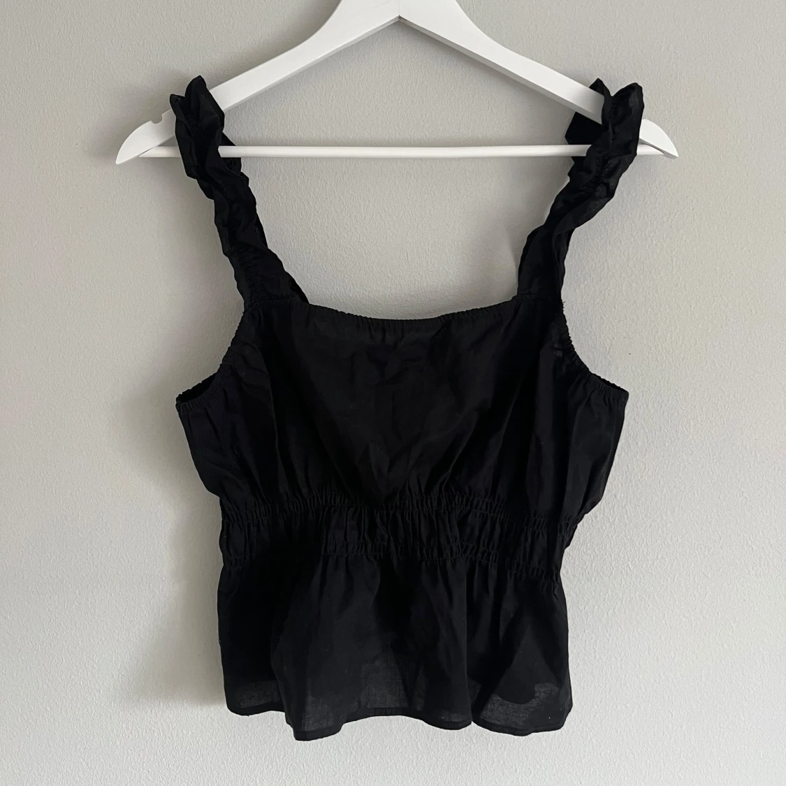 Svart linnetopp med volangdetaljer