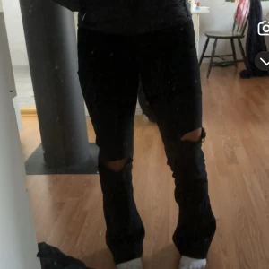 Svarta bootcut jeans - Snygga svarta bootcut jeans med en klassisk passform. Har klippt två hål som framhävs i bilderna. Perfekta för en stilren look. Midwaist. 