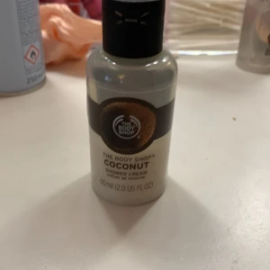 Coconut Shower Cream från The Body Shop - En krämig duschkräm med en härlig doft av kokos från The Body Shop. Flaskan innehåller 60 ml och är perfekt för att återfukta och rengöra huden med en exotisk doftupplevelse.