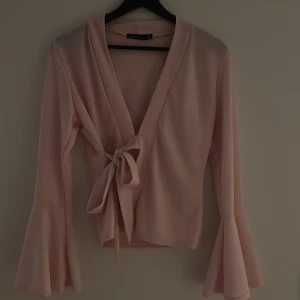Rosa omlottopp från Boohoo - Säljer en söt rosa omlottopp från Boohoo med långa ärmar och knytning framtill. Man kan knyta om och knyta själv.🩷🥰