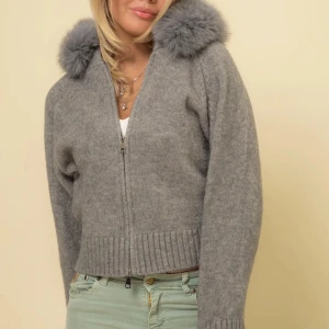 Grå stickad jacka med pälskrage - Säljer en mysig grå stickad jacka med dragkedja och päls från Alessa. Den är helt ny!!! Storlek 36 men passar 38 också!