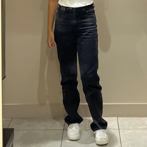 Weekday Rowe svarta jeans - Raka svarta jeansbyxor med en klassisk design. De har en normal passform och är perfekta för en stilren look. Passar bra till både vardag och mer uppklädda tillfällen.