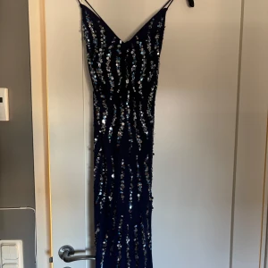 Mörkblå paljettklänning från River Island - Snygg mörkblå klänning från River Island med glittrande paljetter. Köpt för 1300kr tror jag. Använd 1 gång, storlek 12 petite men sitter som en storlek S. 