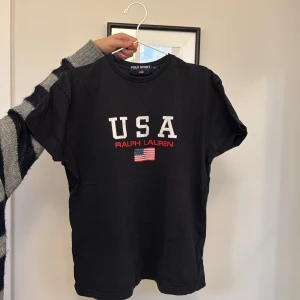 Retro T-shirt från Ralph Lauren - Säljer en svart t-shirt från Ralph Lauren, köpt på beyond retro och är i en vintage stil. 