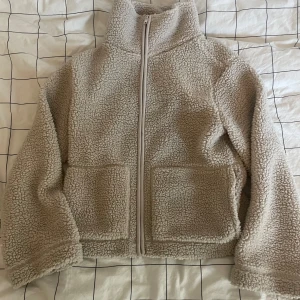 Beige teddyjacka lager 157 - Säljer en mysig beige teddyjacka från 157 med dragkedja framtill. Jackan har en hög krage och två stora fickor. Säljer den då den är för liten💗