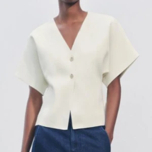 Vit kortärmad blus med knappar Zara - Snygg vit blus med korta ärmar och två knappar framtill. Perfekt för en stilren look. Passar bra till både jeans och kjol. Bild p.g.a för liten för mig. Kontakta mig för fler bilder. Den säljs inte längre på hemsidan!